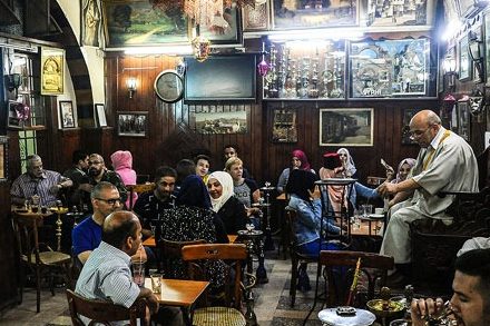 Personas escuchando a un hakawati en un café de Damasco